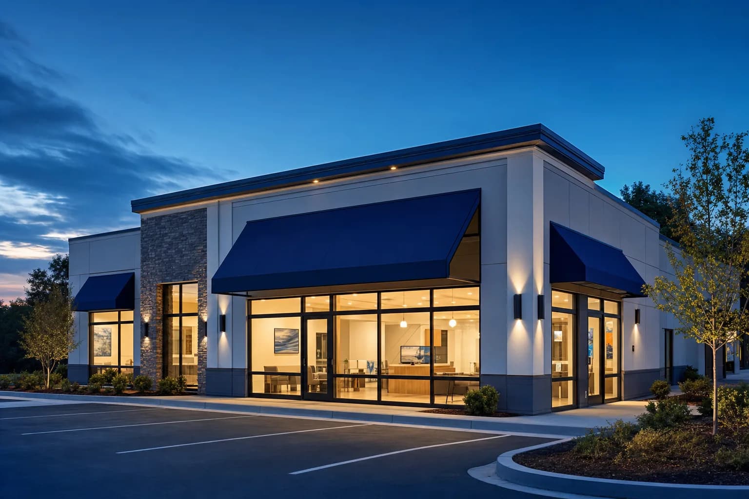 A service business storefront lit from within at dusk